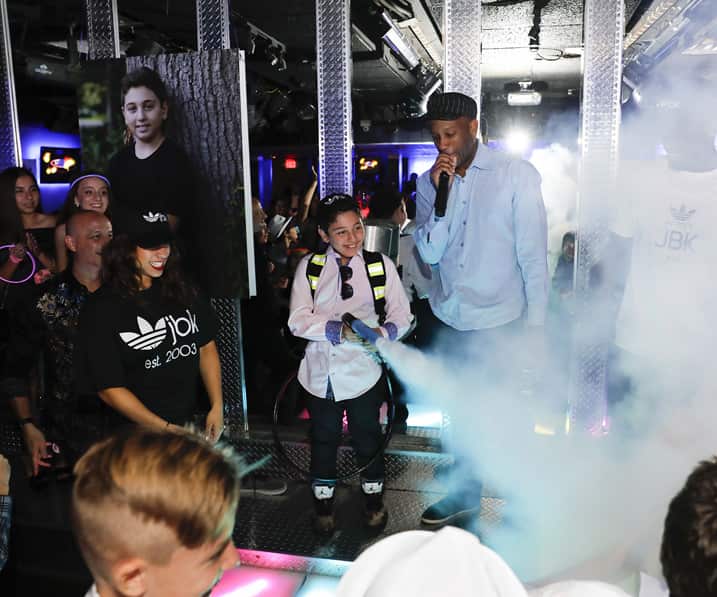 Man on a microphone while people party